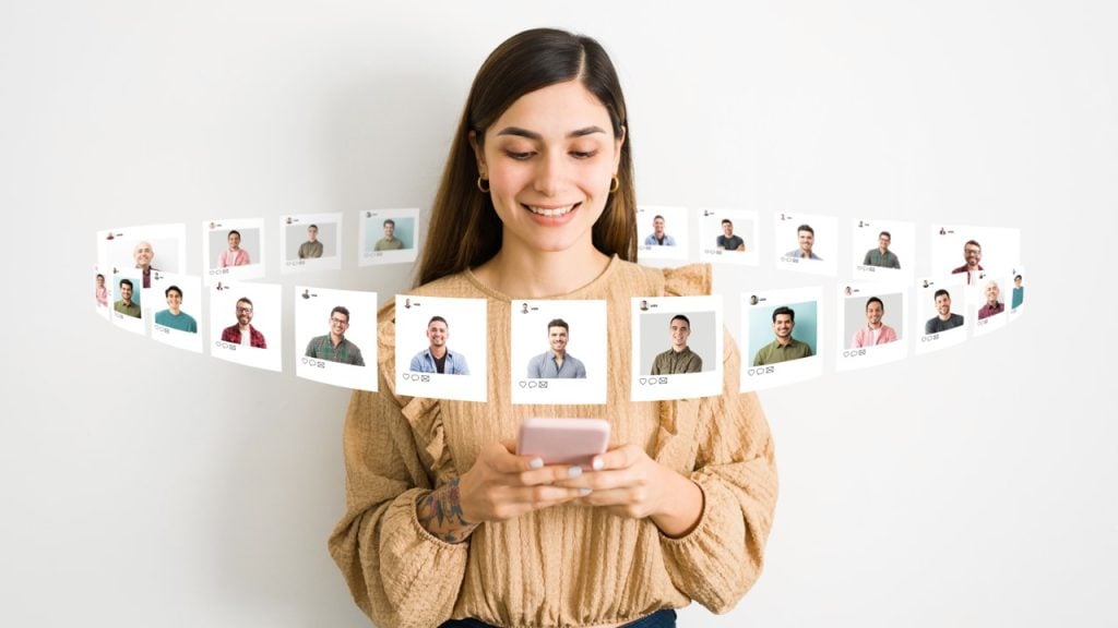 Mulher sorrindo olhando celular com fotos de perfis em volta